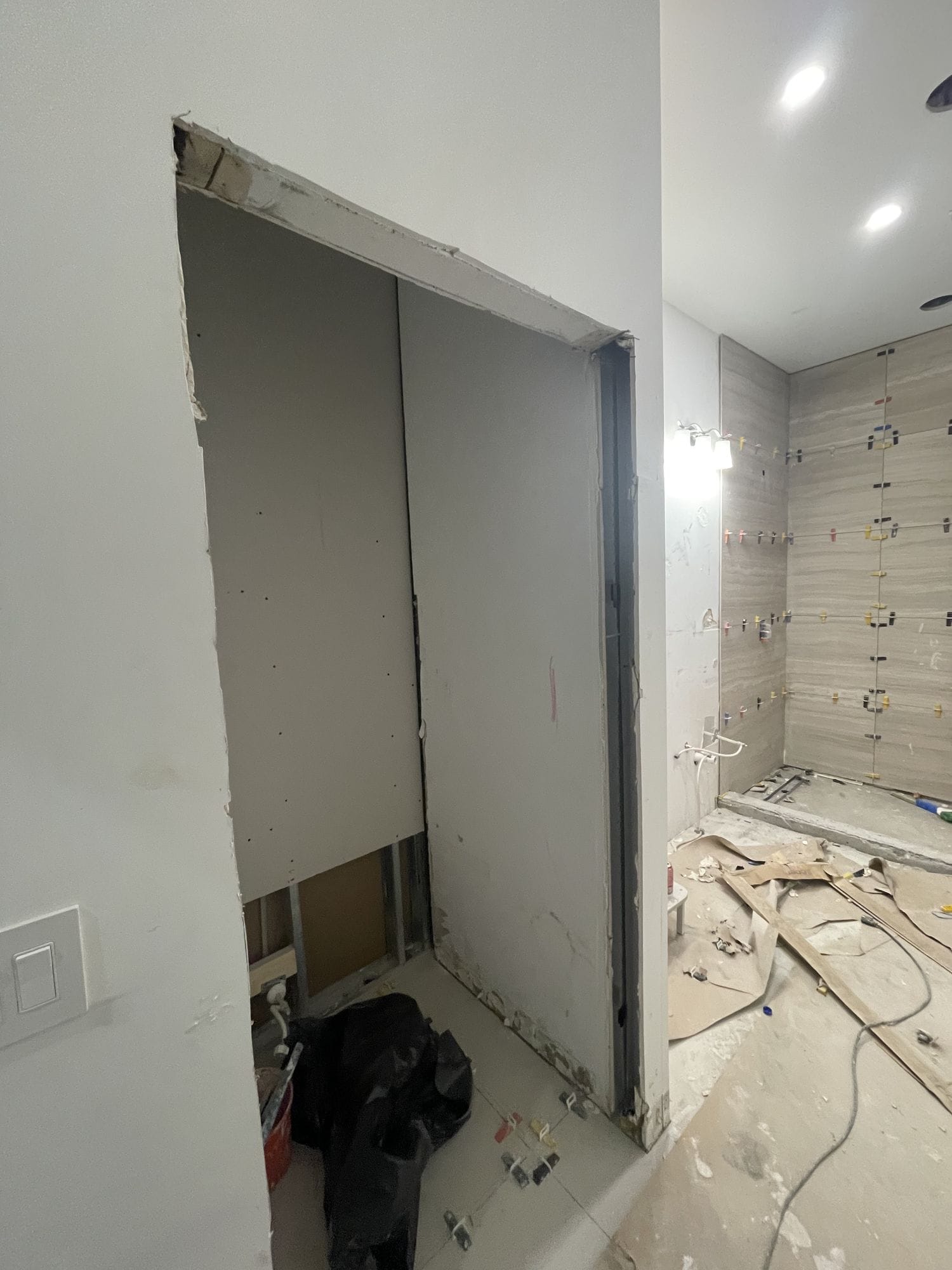 Bathroom stripped back during construction with the wall opening re-framed and tile backer board set