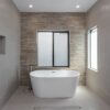 Shower area running level with the bathroom floor beside a freestanding bath, with a linear drain