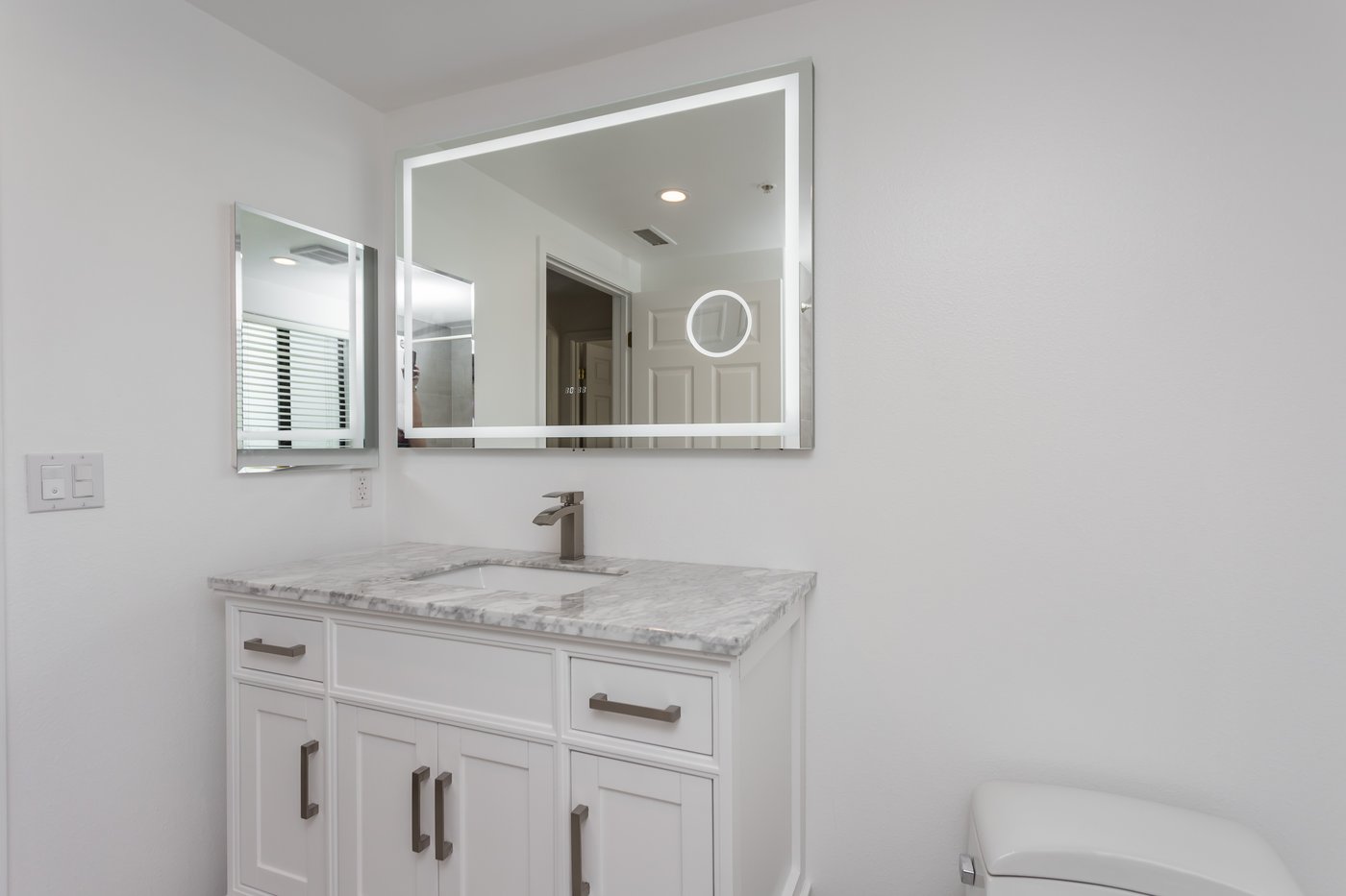 White vanity with a stone top and clear approach space in front of it