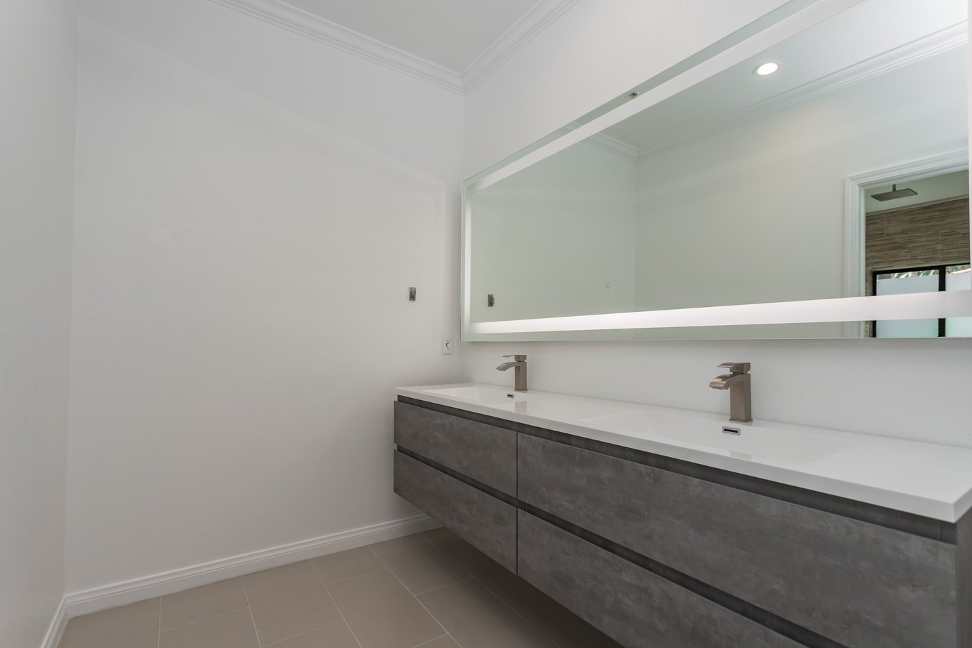 Long wall-hung vanity with twin basins and no floor-mounted cabinet below