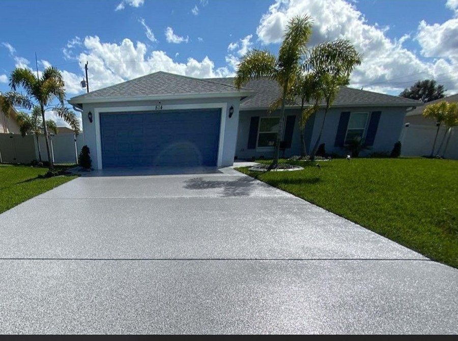 Circular paver driveway with a central planted island and low-level lighting at dusk