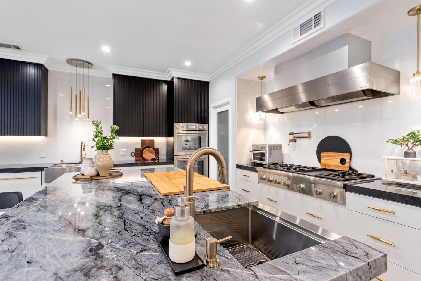 Marble island with an undermount sink, brass tapware and open circulation on both sides