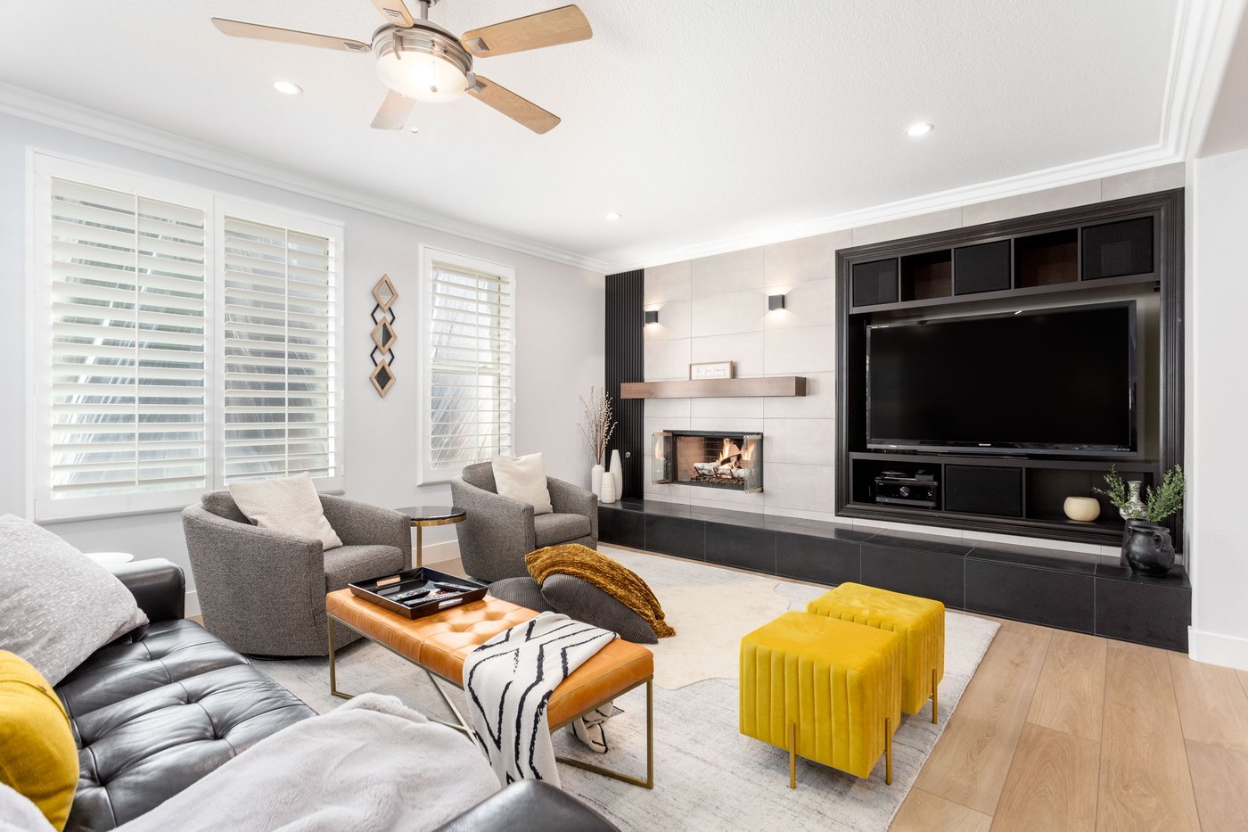 Living area with a linear fireplace and media wall, open to the kitchen beyond
