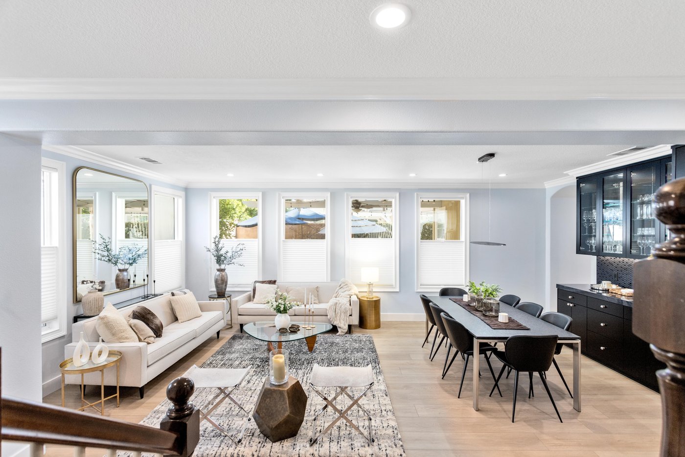 Open-plan living area looking through dining to the kitchen beyond, with continuous wood flooring