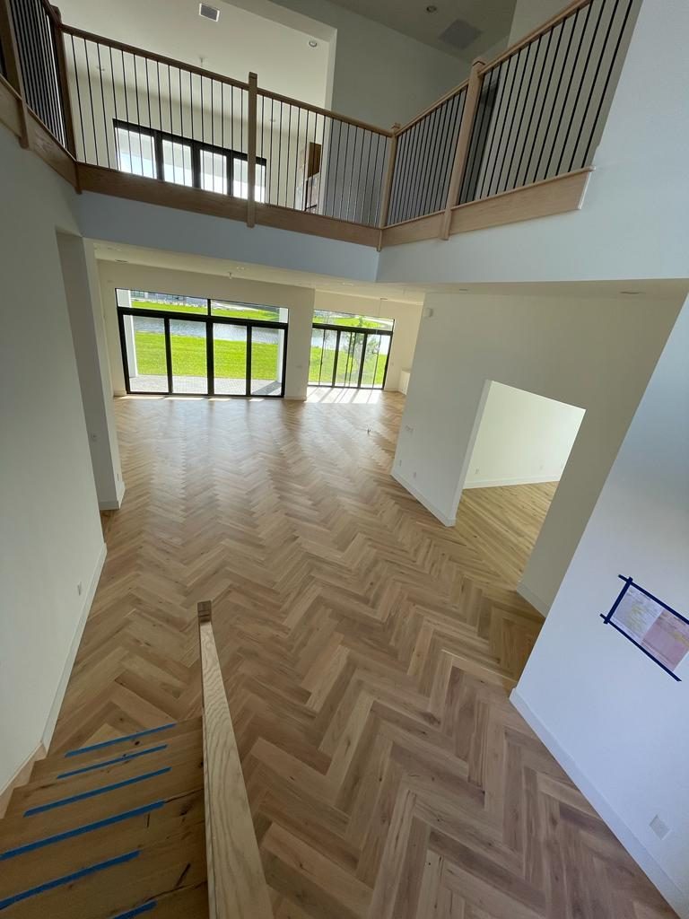 Herringbone floor seen from the upper landing, showing how the pattern reads as a single field across the whole level