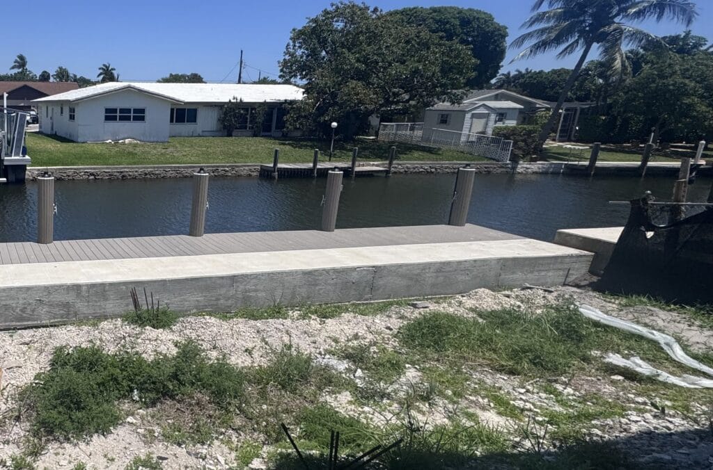 New concrete seawall cap and composite dock decking on a South Florida canal, photographed on an Elbaz Construction project