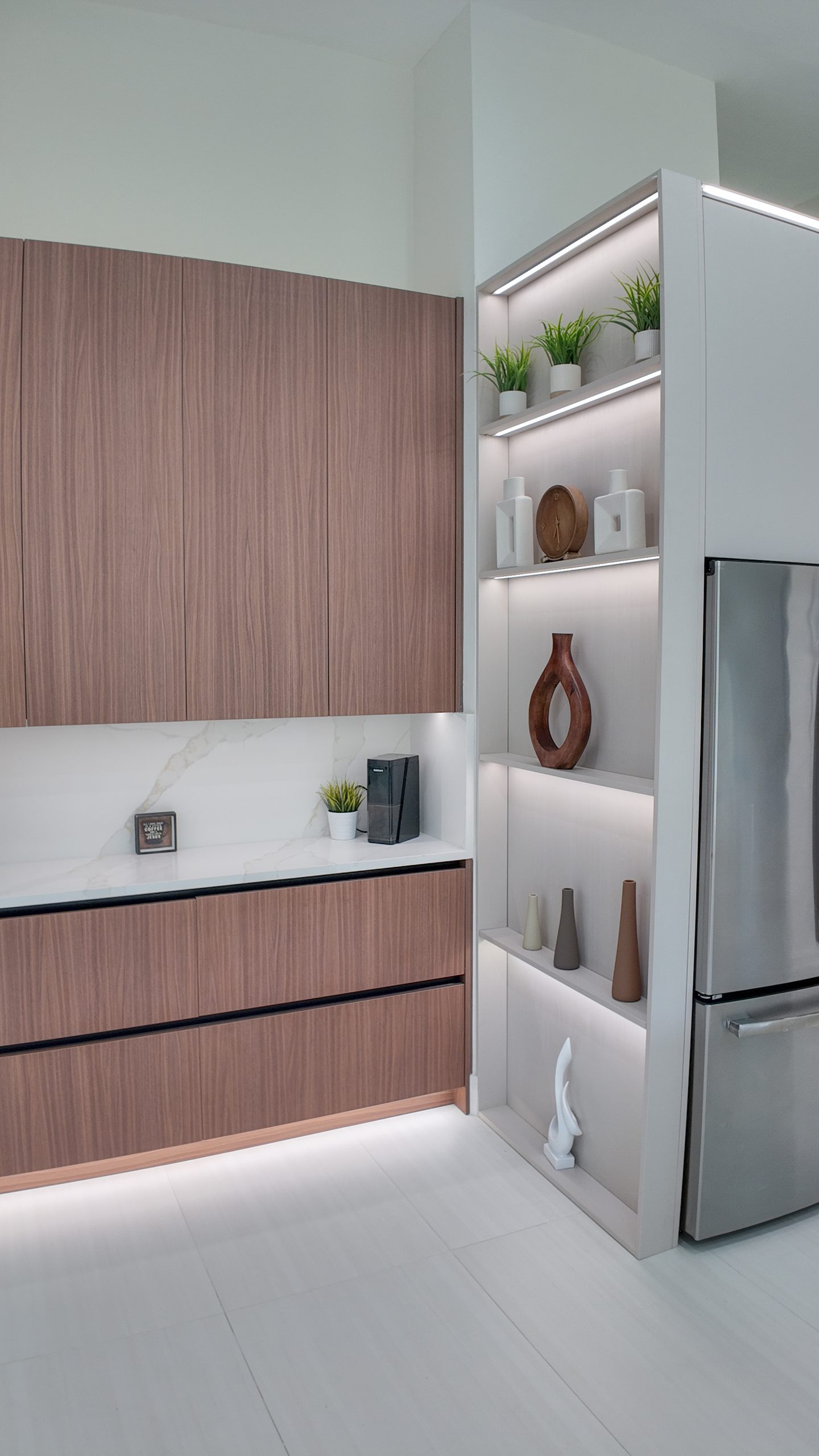 A pantry and display run in timber and white, refrigerator built in alongside