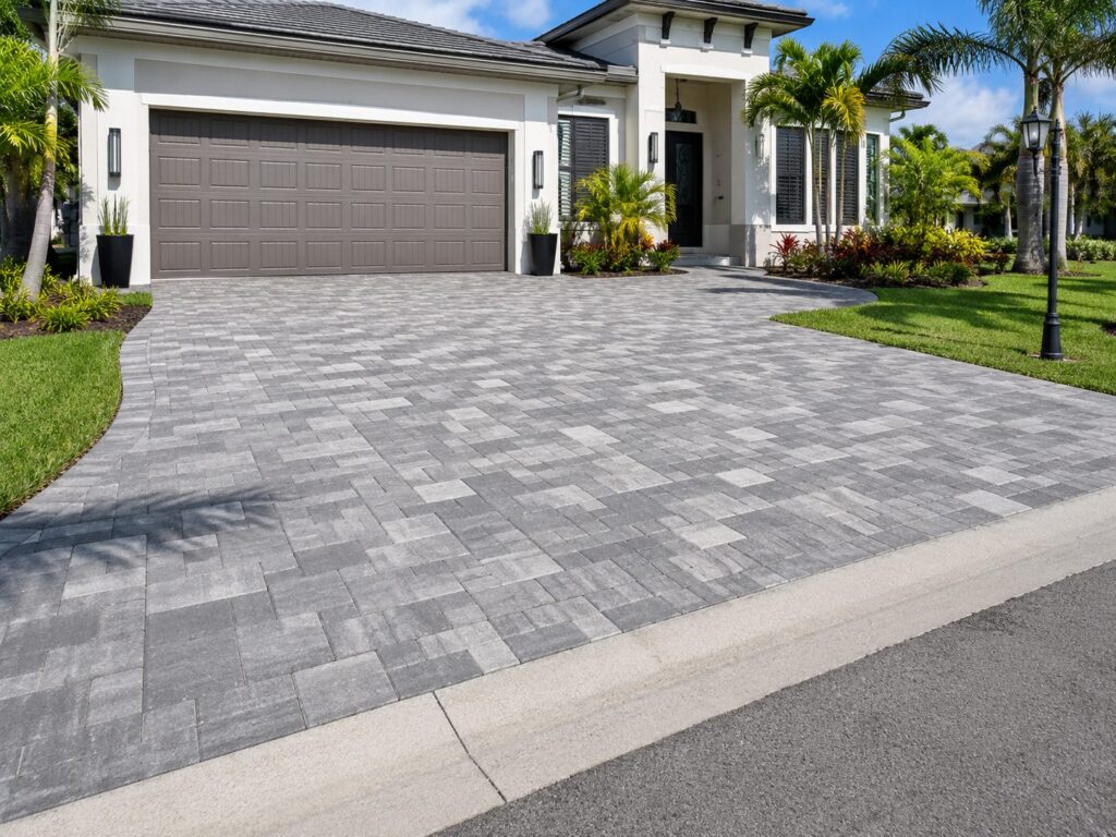 Large-format paver driveway and walkway laid in a running bond with a contrasting soldier-course border