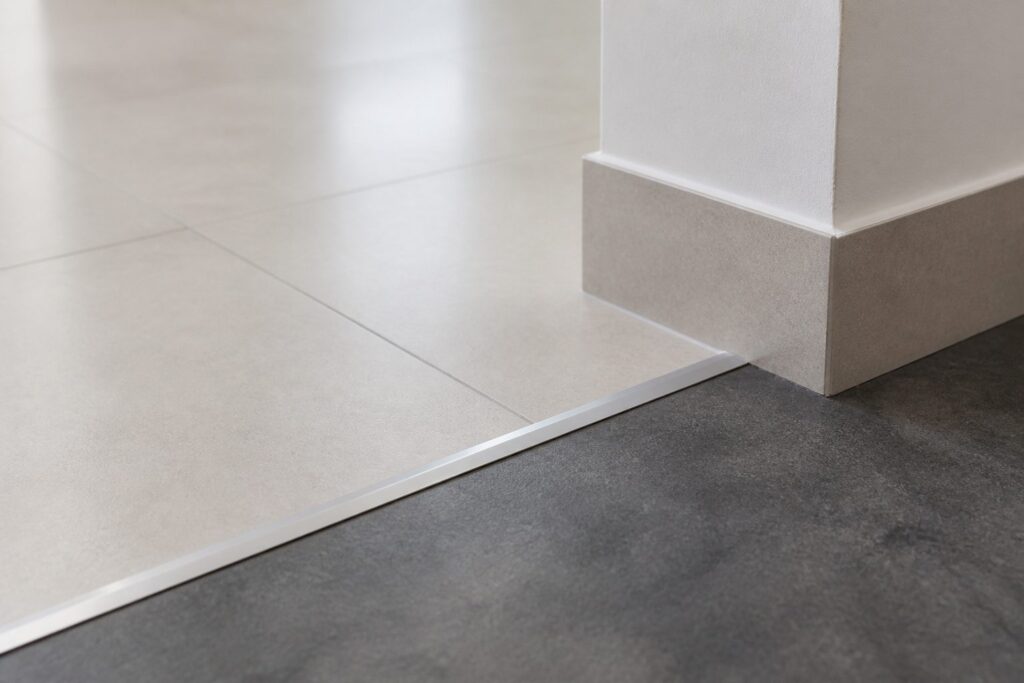 Illustration of a floor finish transition at a metal strip, where one commercial floor material meets another