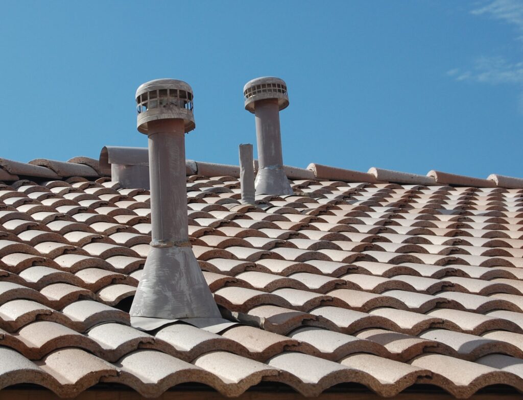 Close view of a roof vent set and flashed into a completed barrel tile field