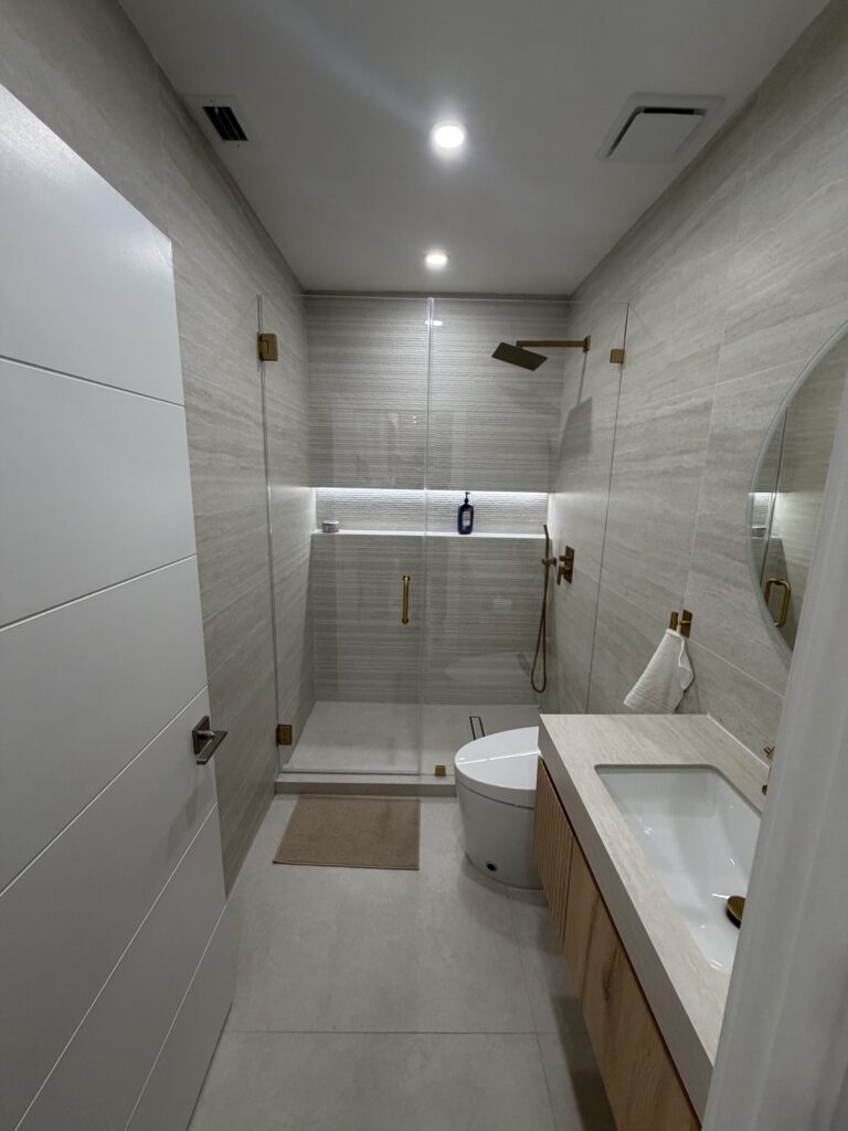 Shower interior showing a recessed niche set into the tiled wall and the mixer controls positioned away from the spray