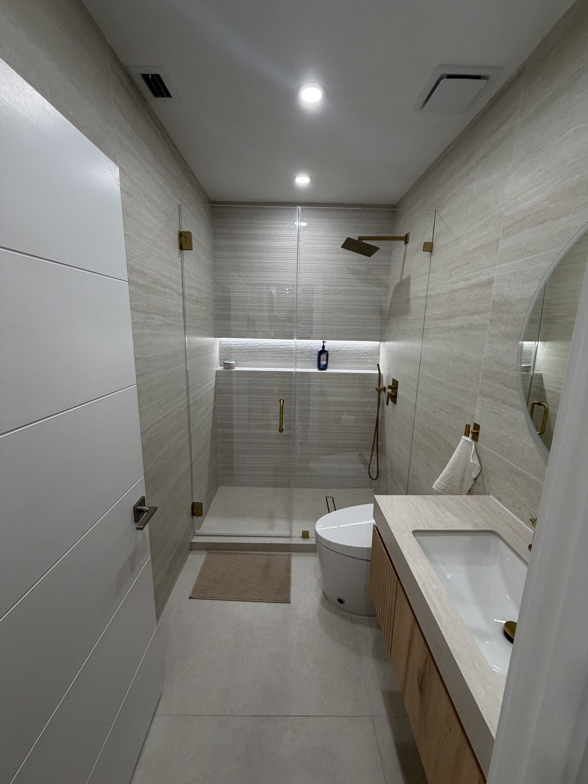 Shower interior showing a recessed niche set into the tiled wall and the mixer controls positioned away from the spray