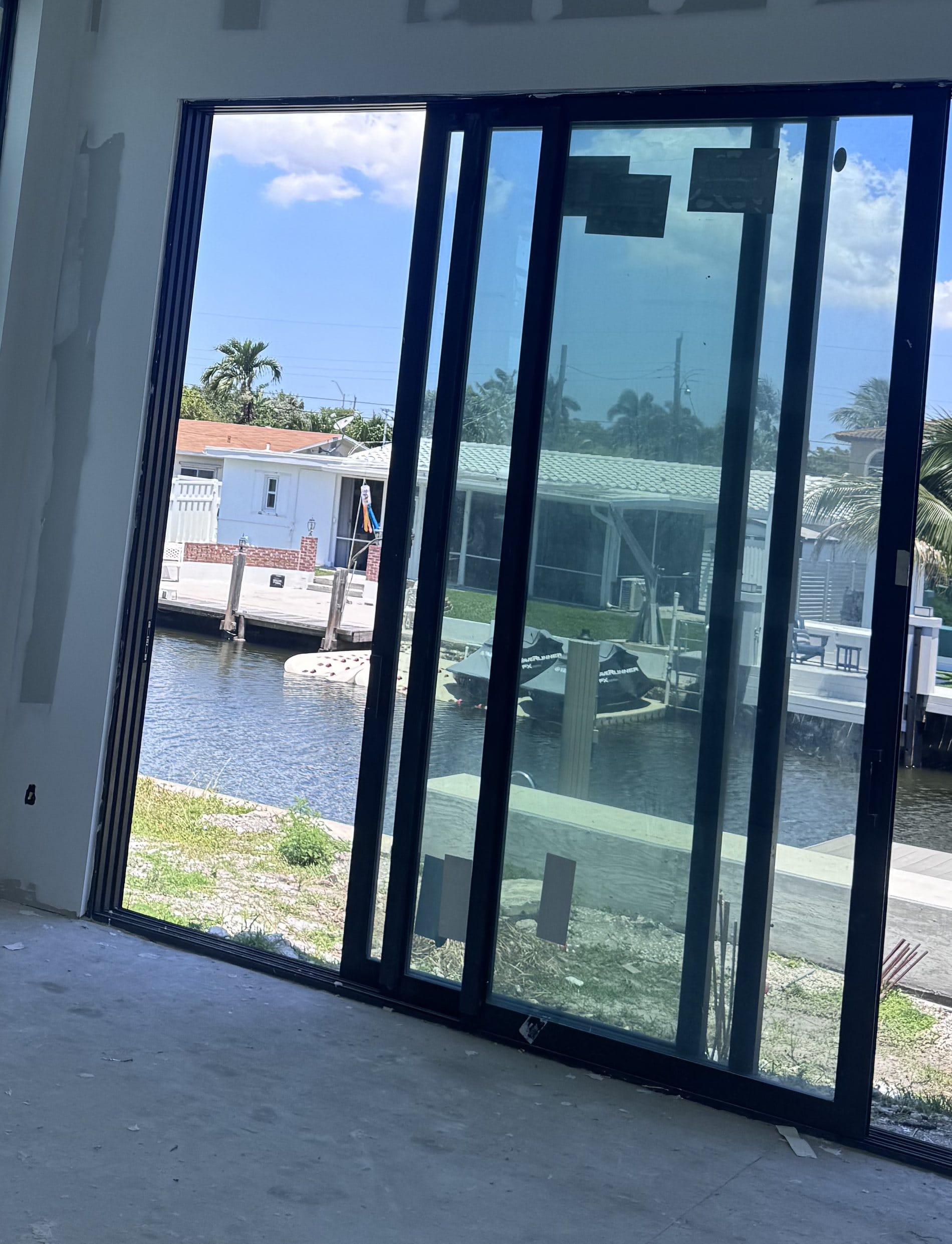 Close-up of the multi-panel sliding glass door, its pocket jamb and the recessed threshold track