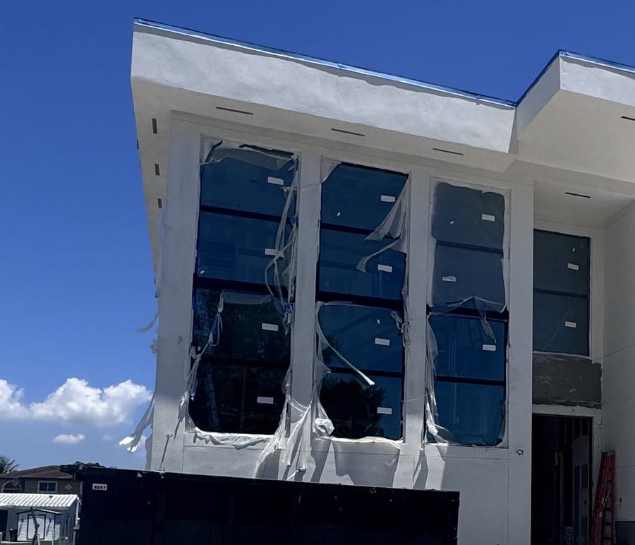 Close-up of the stucco return around the two-storey window opening with protective film still fitted