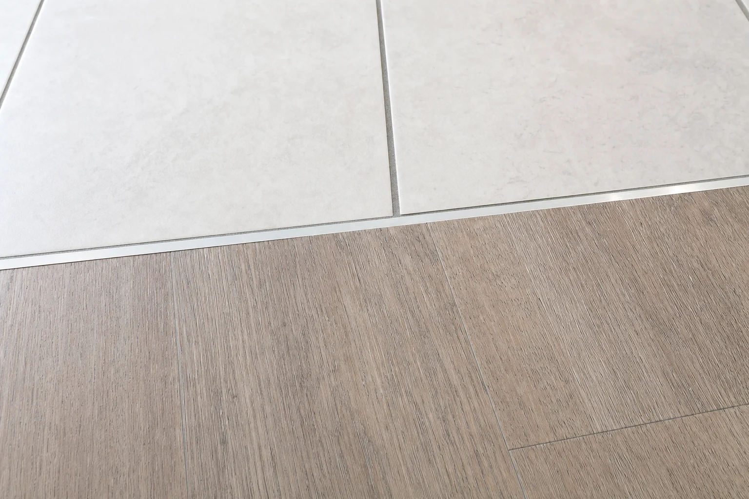 Flush transition strip between two floor finishes in a commercial interior