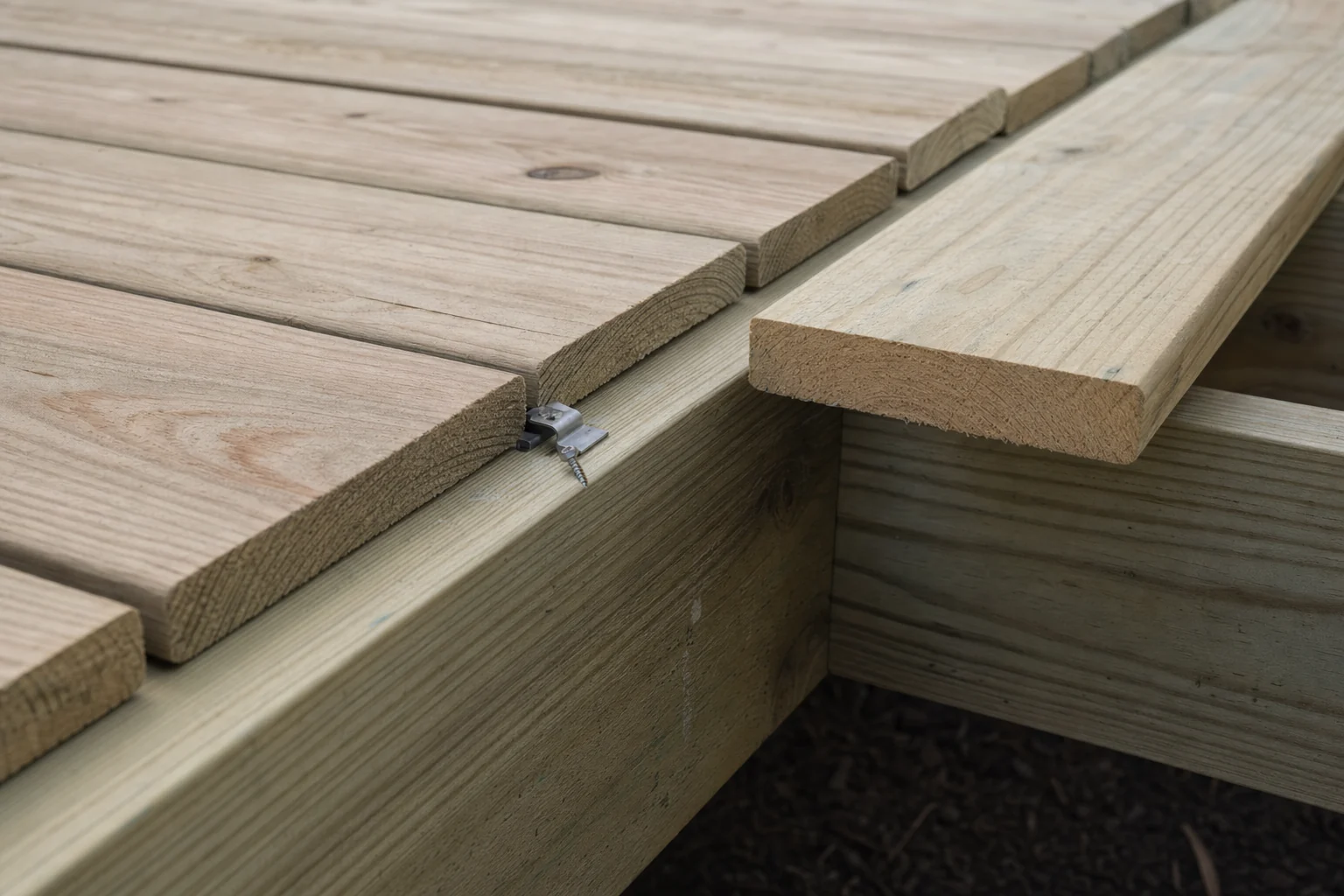 Hidden fastener clips being set between deck boards during installation