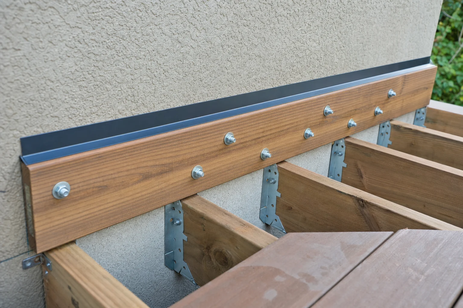 Ledger board and flashing detail where a wood deck meets the house wall