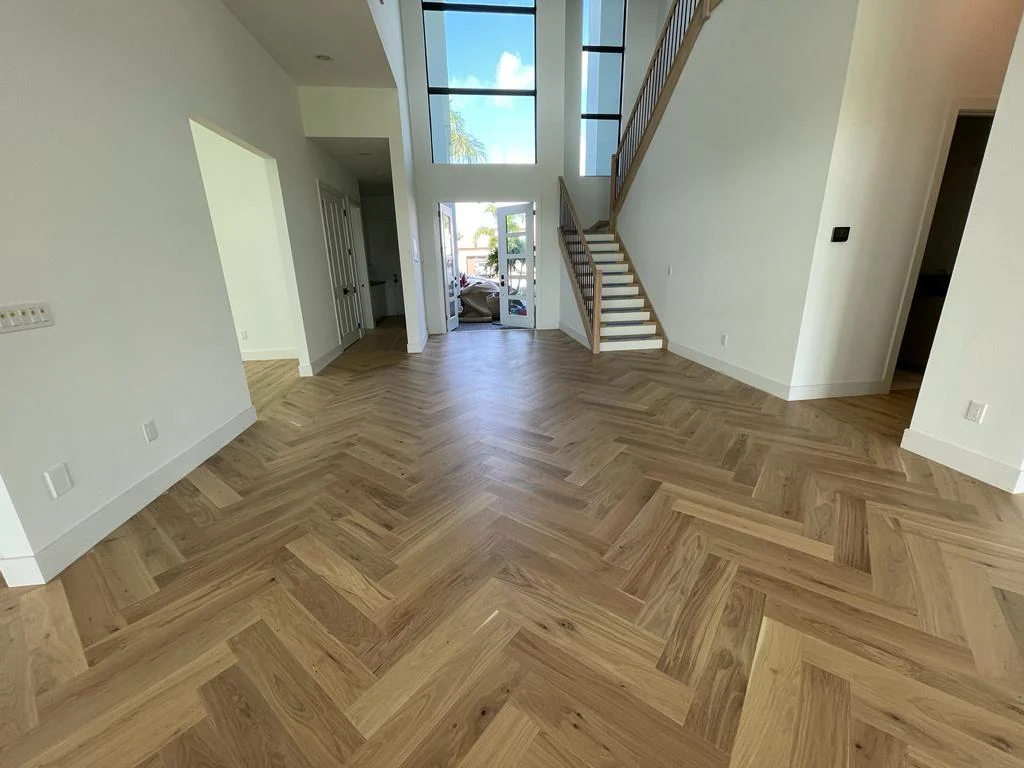 Herringbone wood-look flooring laid through an open-plan living area