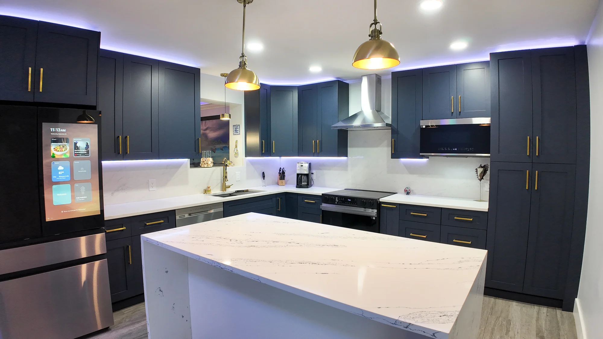 Renovated kitchen island lit by pendant lighting