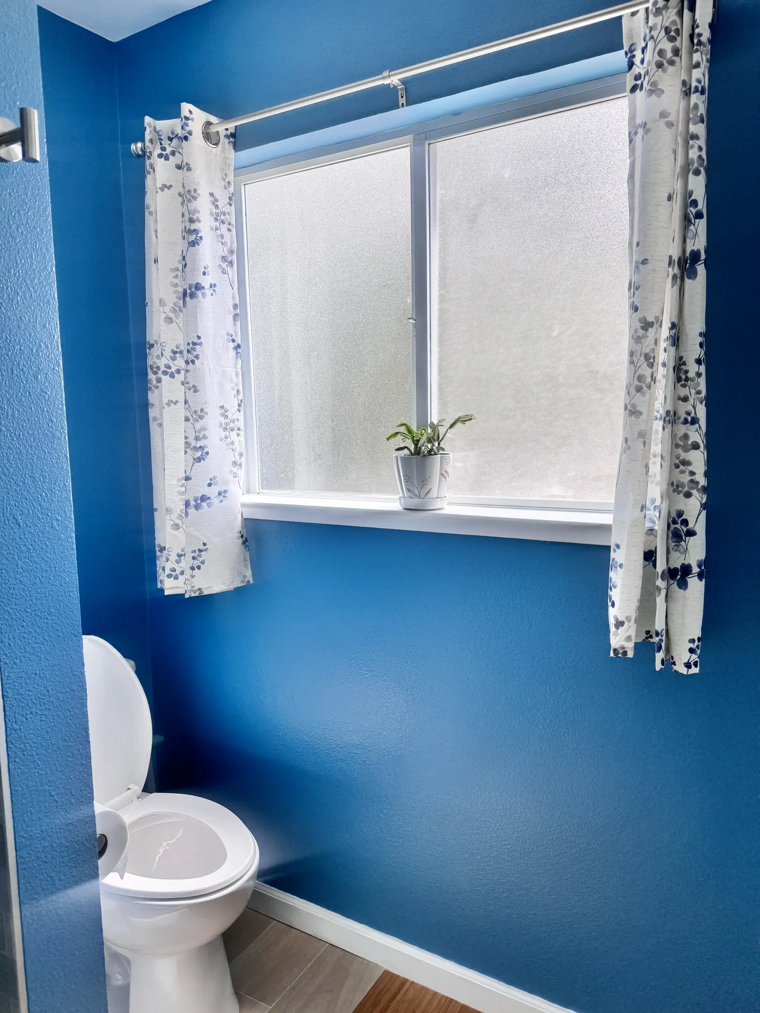 Compact bathroom with toilet and window in a completed Elbaz Construction remodel