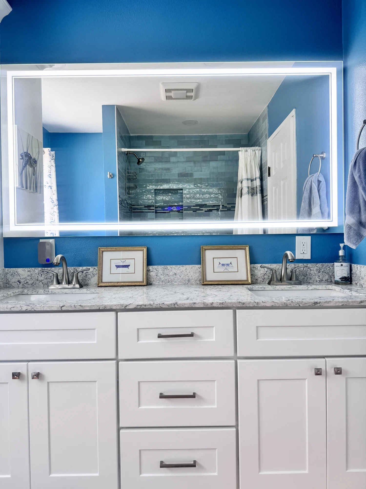 Completed bathroom vanity with a lit mirror