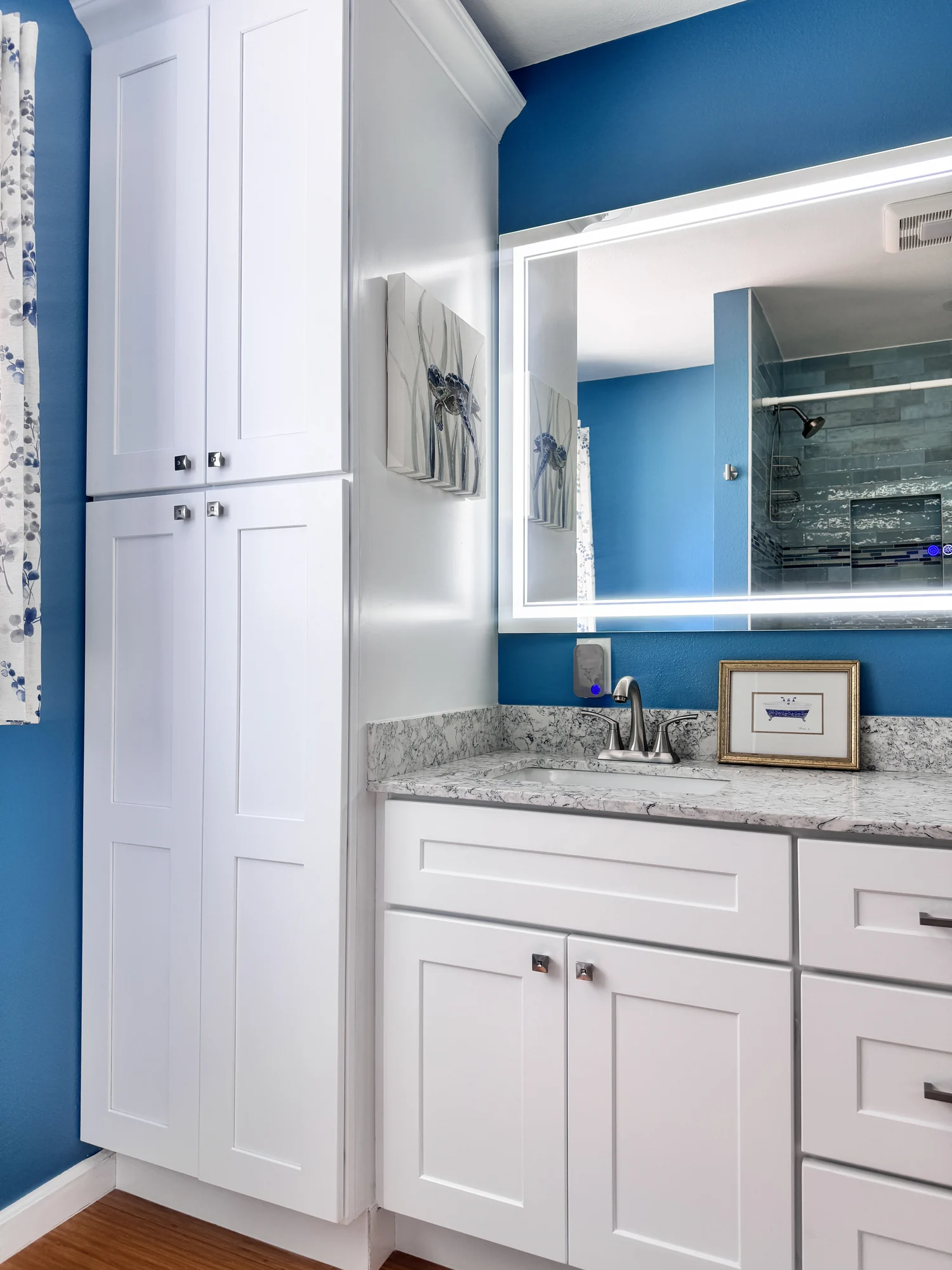 Compact bathroom vanity beside a tall storage cabinet