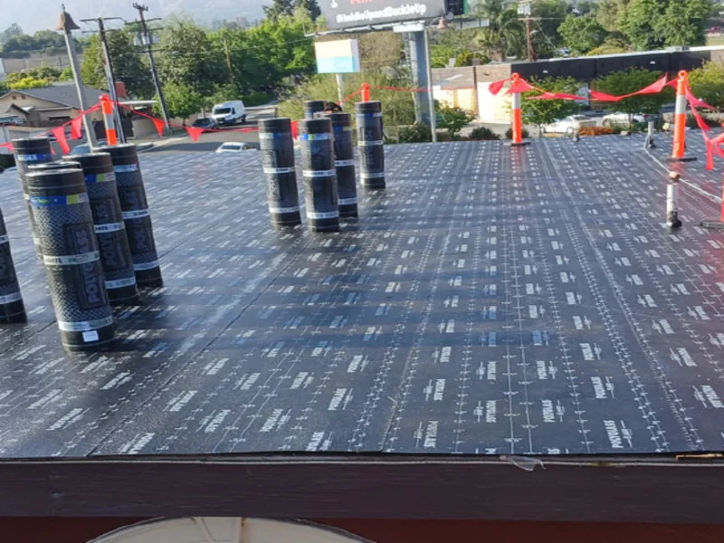 Underlayment rolls staged on a prepared flat roof
