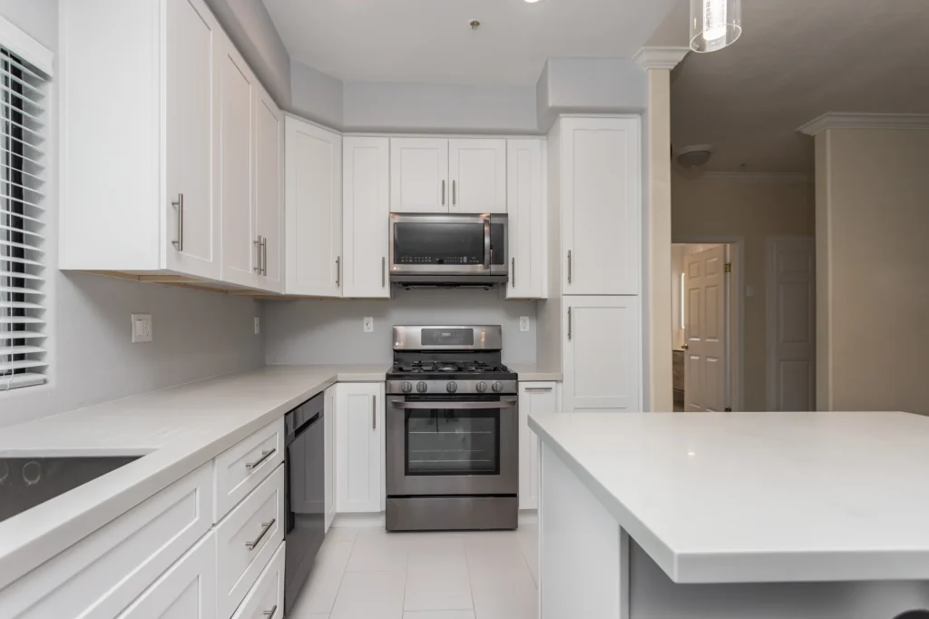 Completed white kitchen with island and range in an Elbaz Construction home renovation