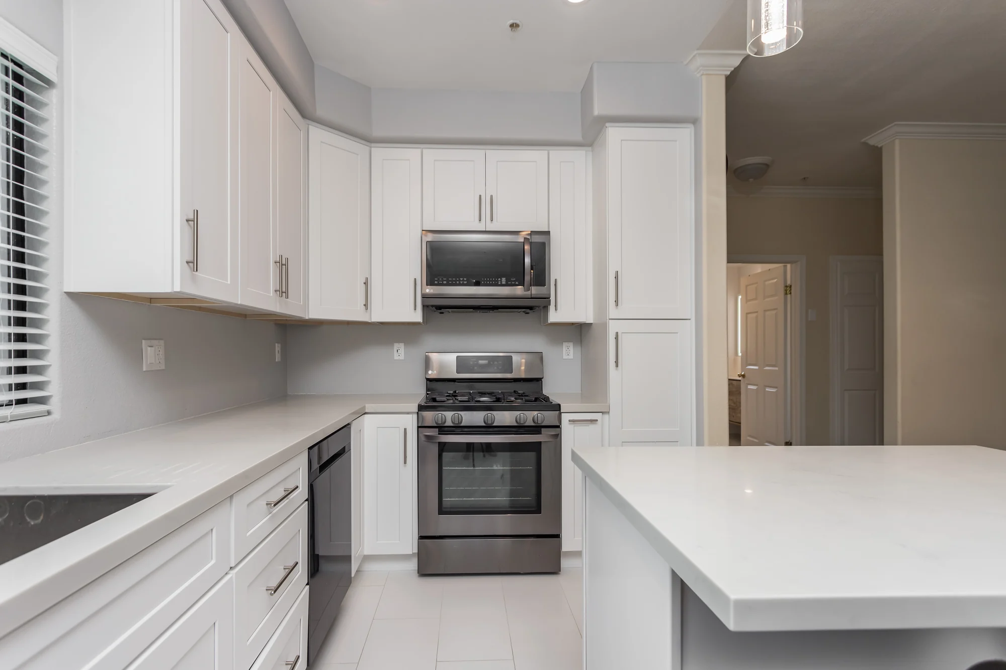 Completed white kitchen with island and range in an Elbaz Construction home renovation