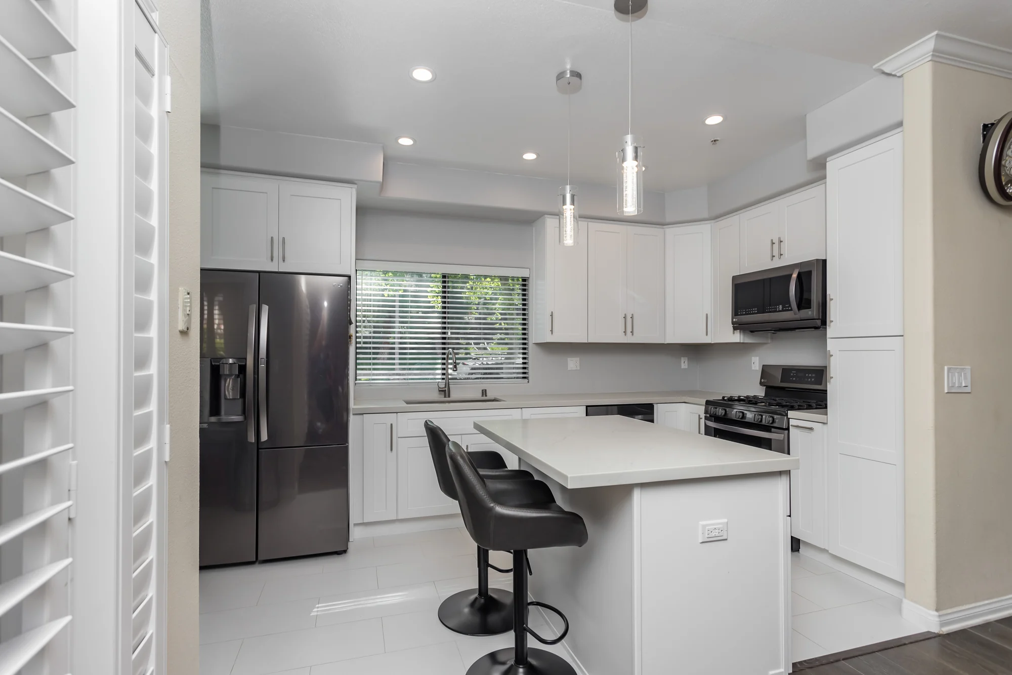 Renovated kitchen with island, tall units and stainless appliances
