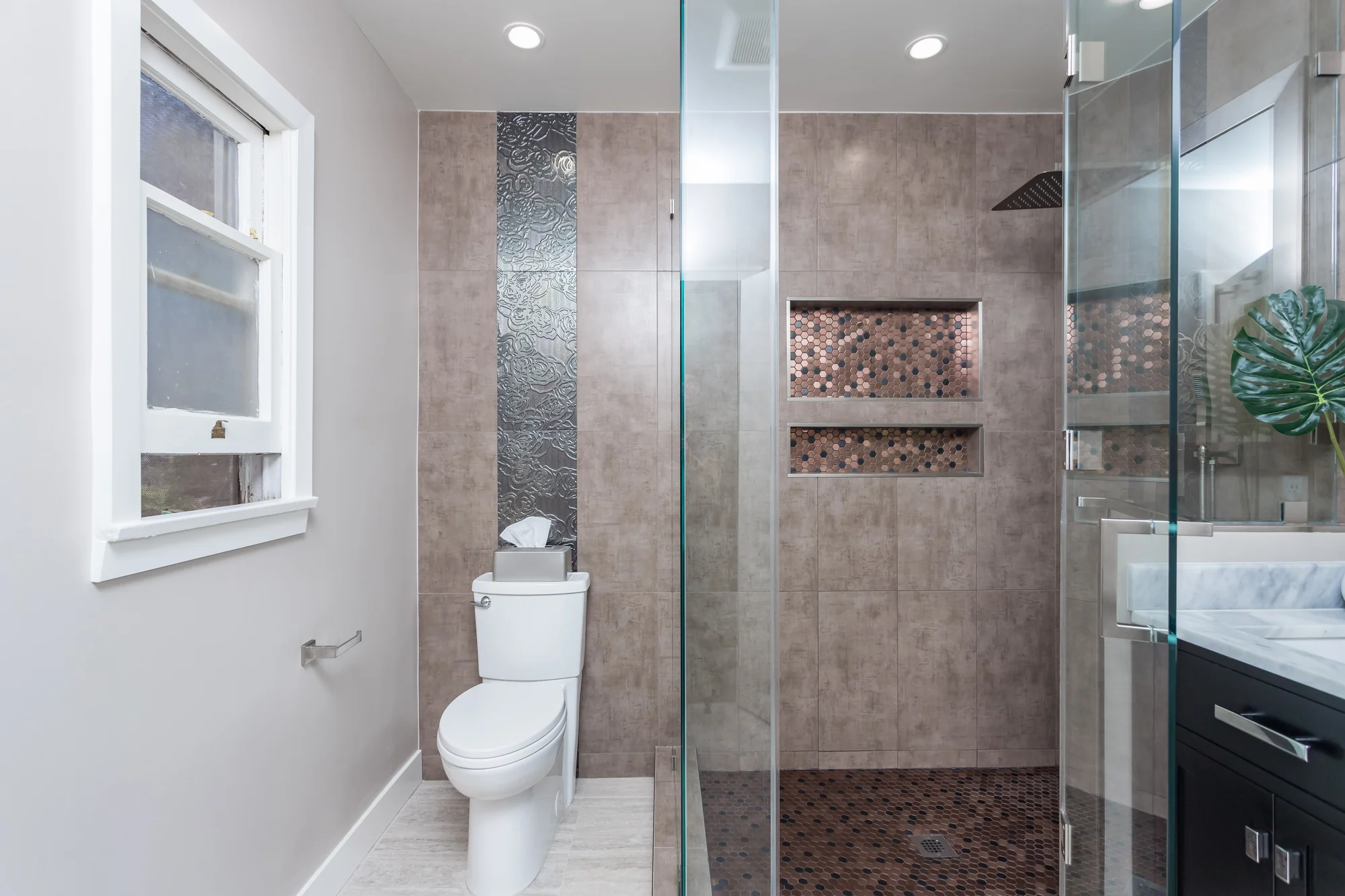 Completed bathroom with tiled shower and dark vanity