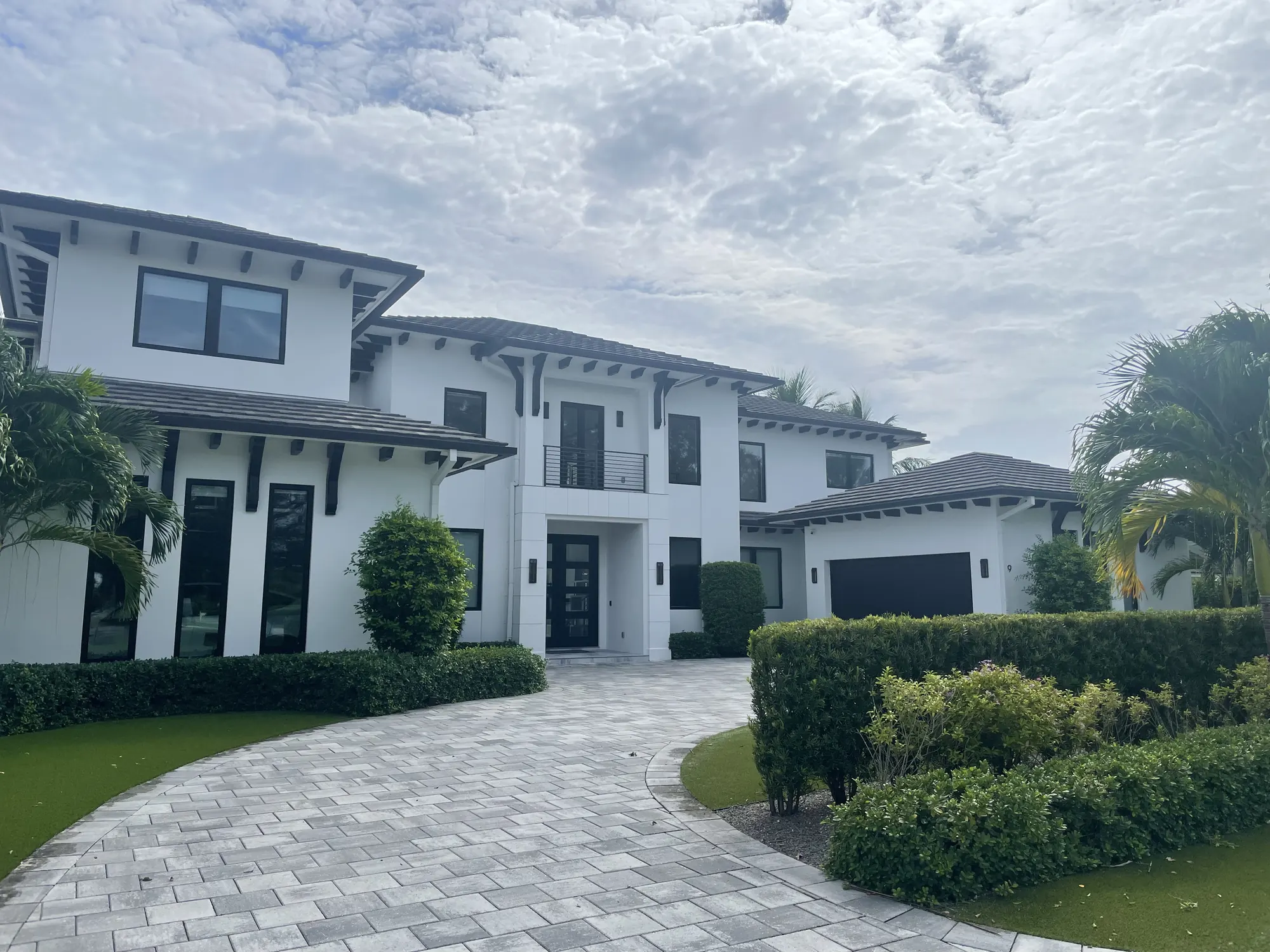 Two-storey home with new windows and a paver driveway