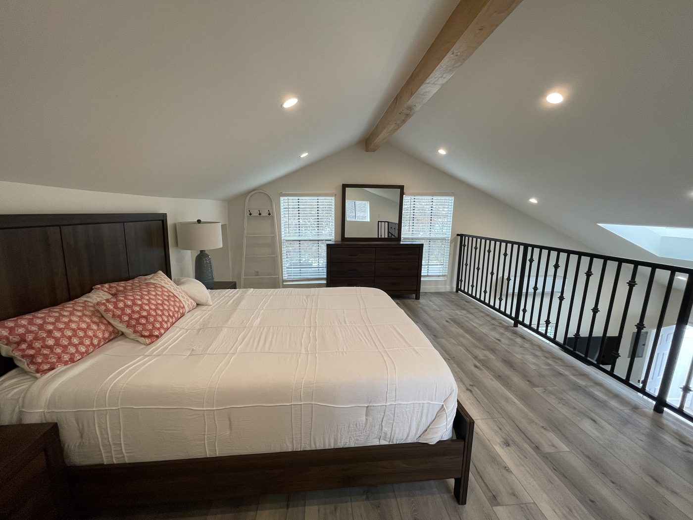 ADU sleeping loft under a vaulted ceiling with an exposed beam