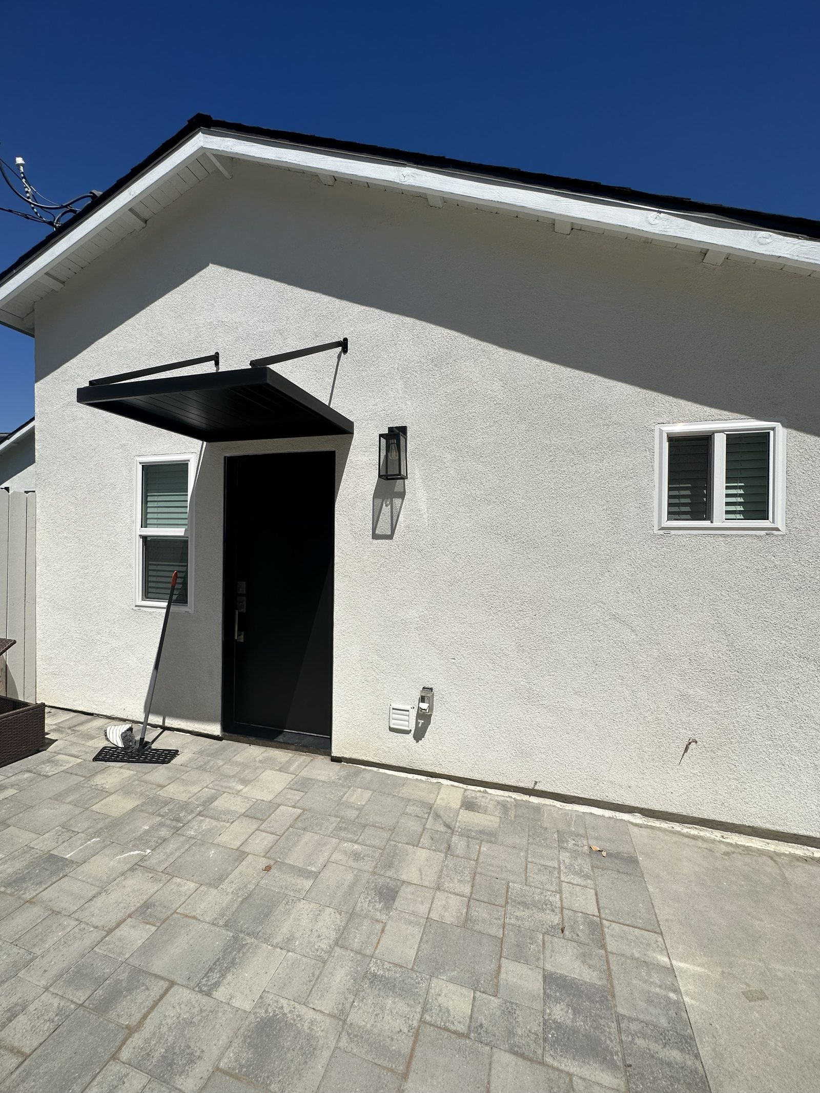 Exterior of a finished detached ADU with white stucco and black trim