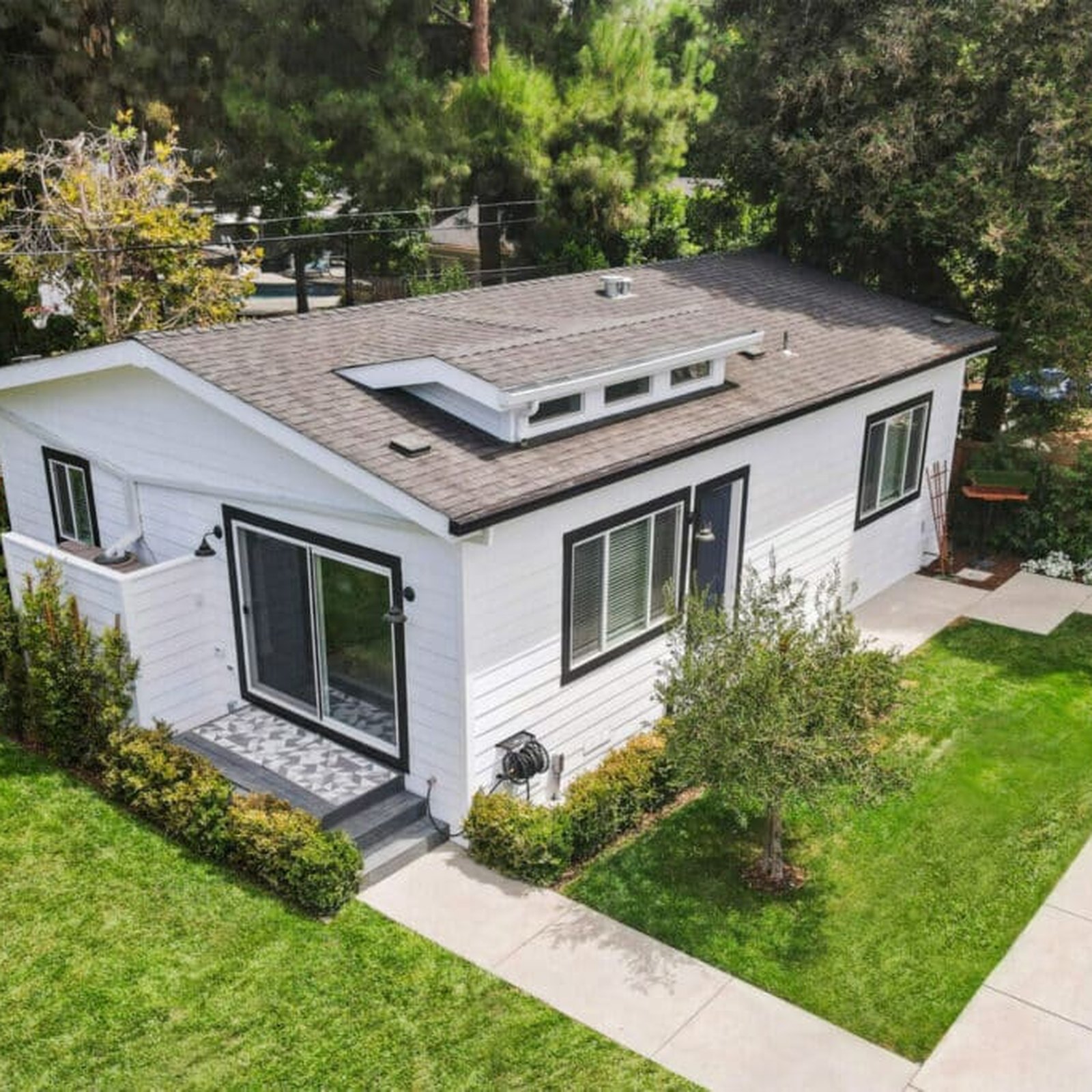 Detached ADU with white exterior siding and landscaped yard