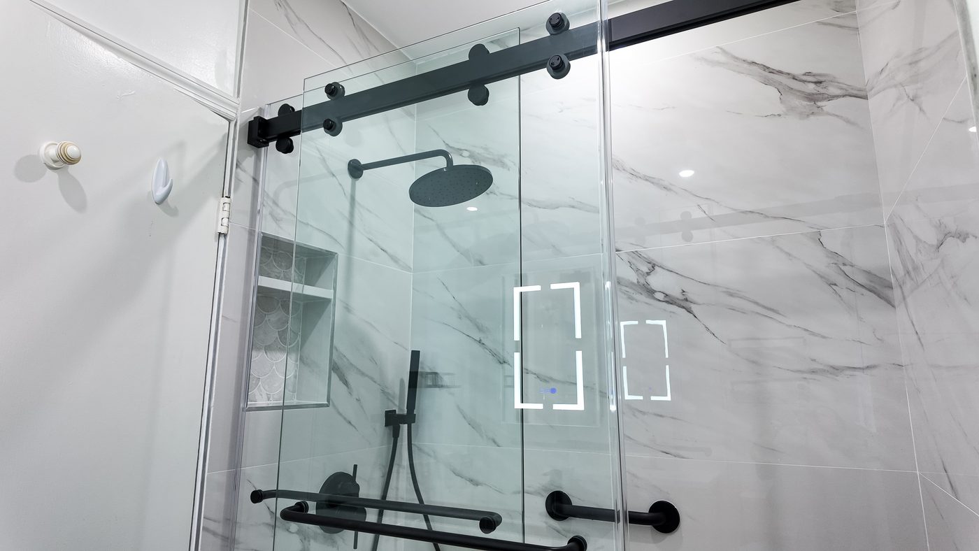 Shower enclosure with a recessed niche and matt black fittings, seen from the room