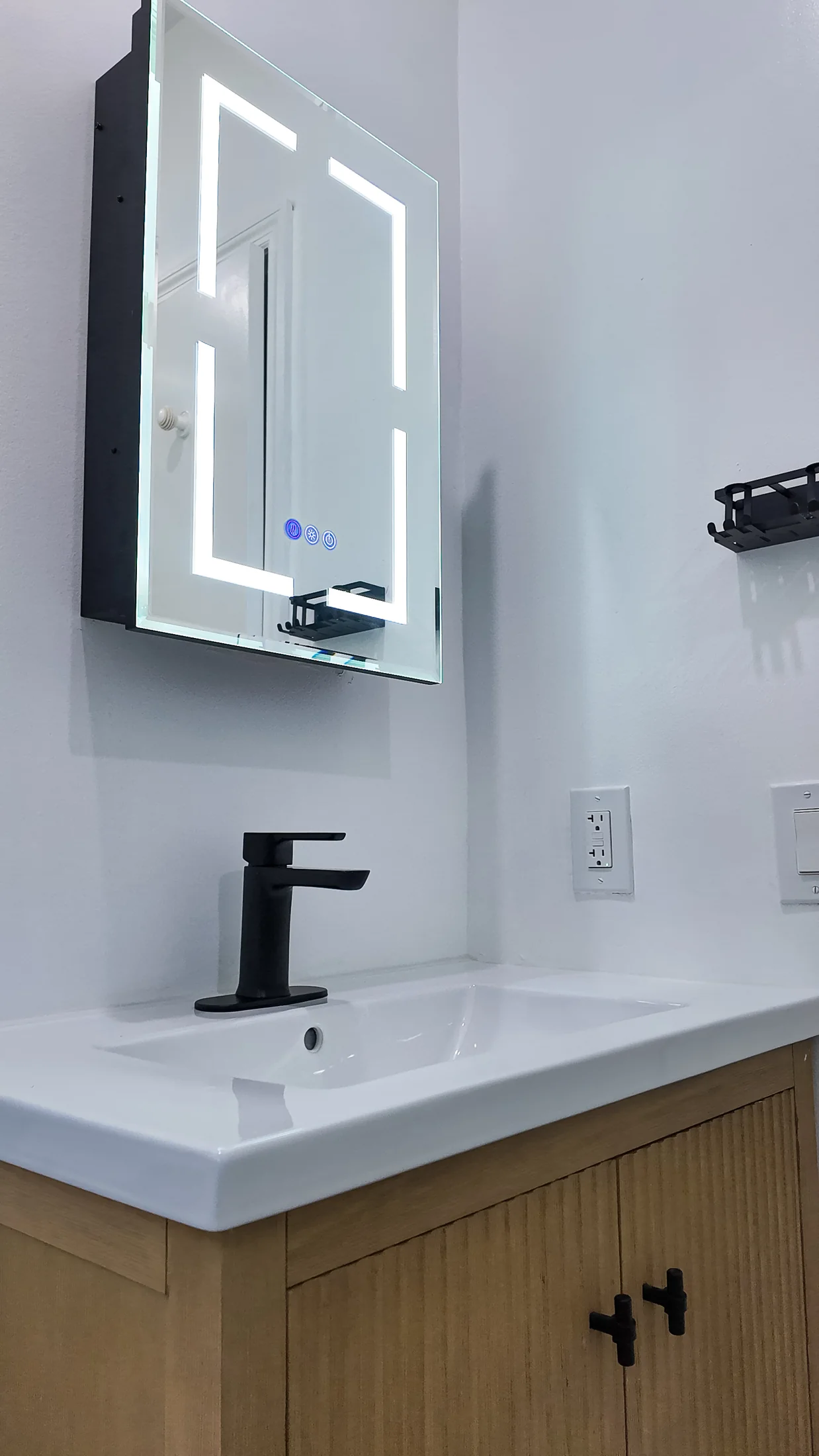 Fluted timber vanity unit with a white basin top and matt black tap