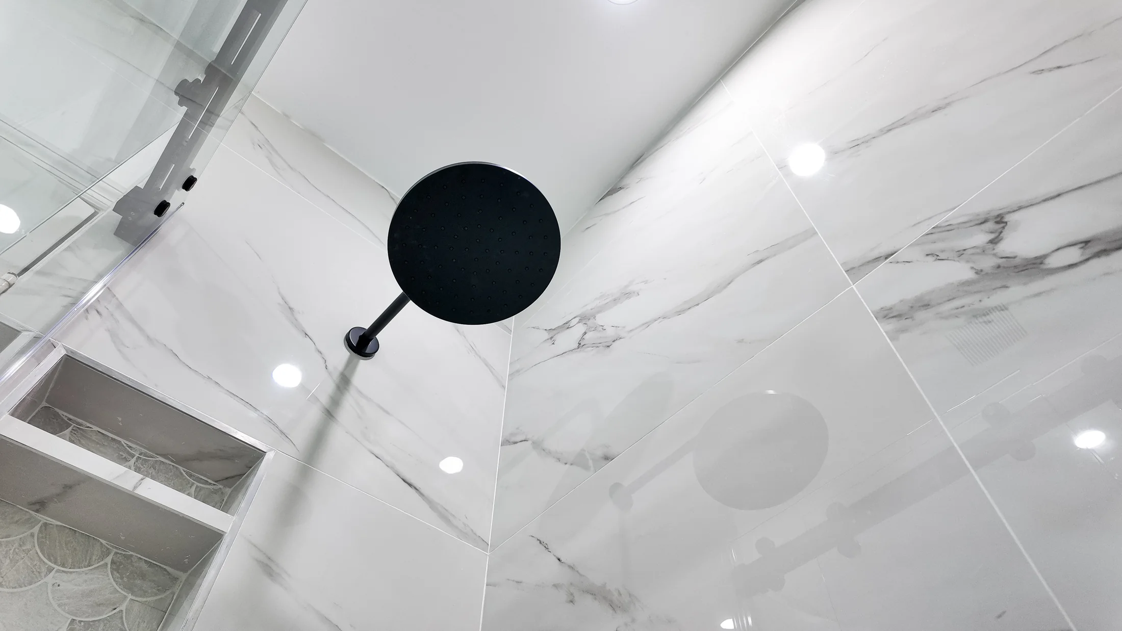 Large-format marble-look wall tile with minimal grout lines in the shower