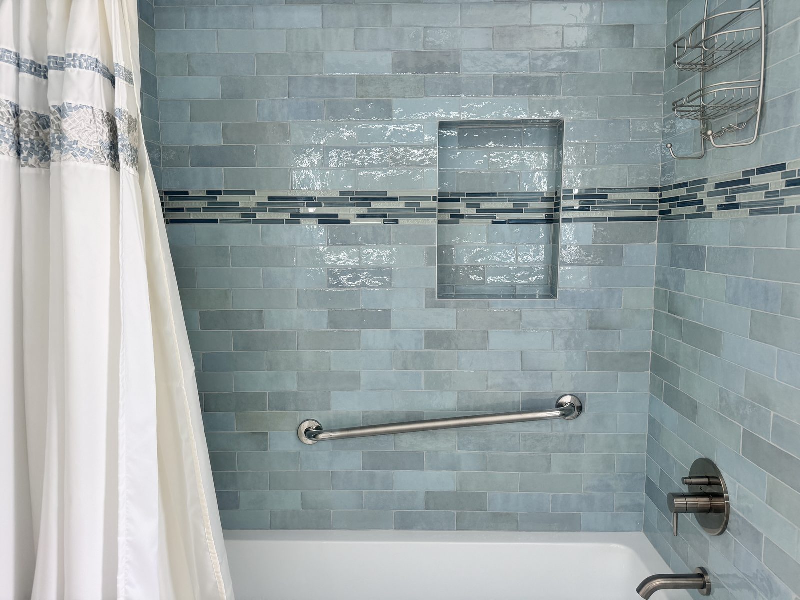 Completed bathroom remodel with tiled shower surround