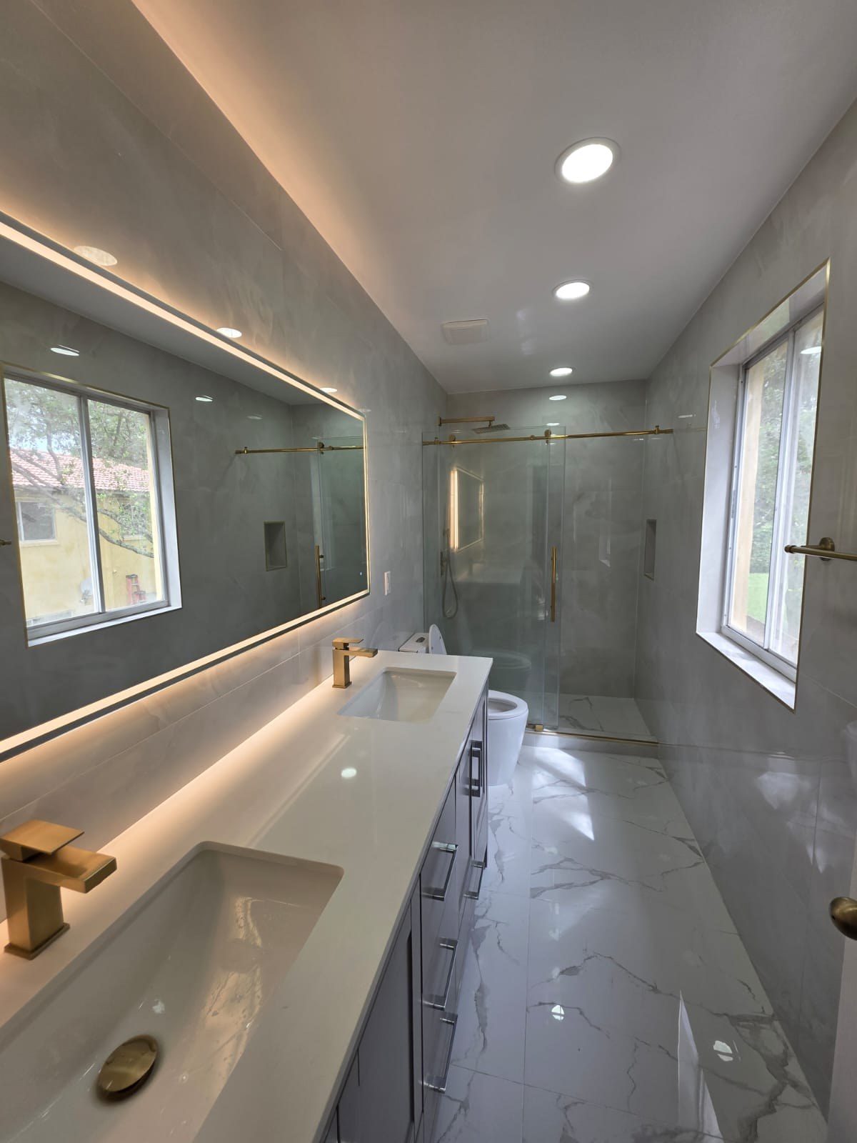 Grey Marble-Look Bathroom Remodel with Frameless Glass Showers