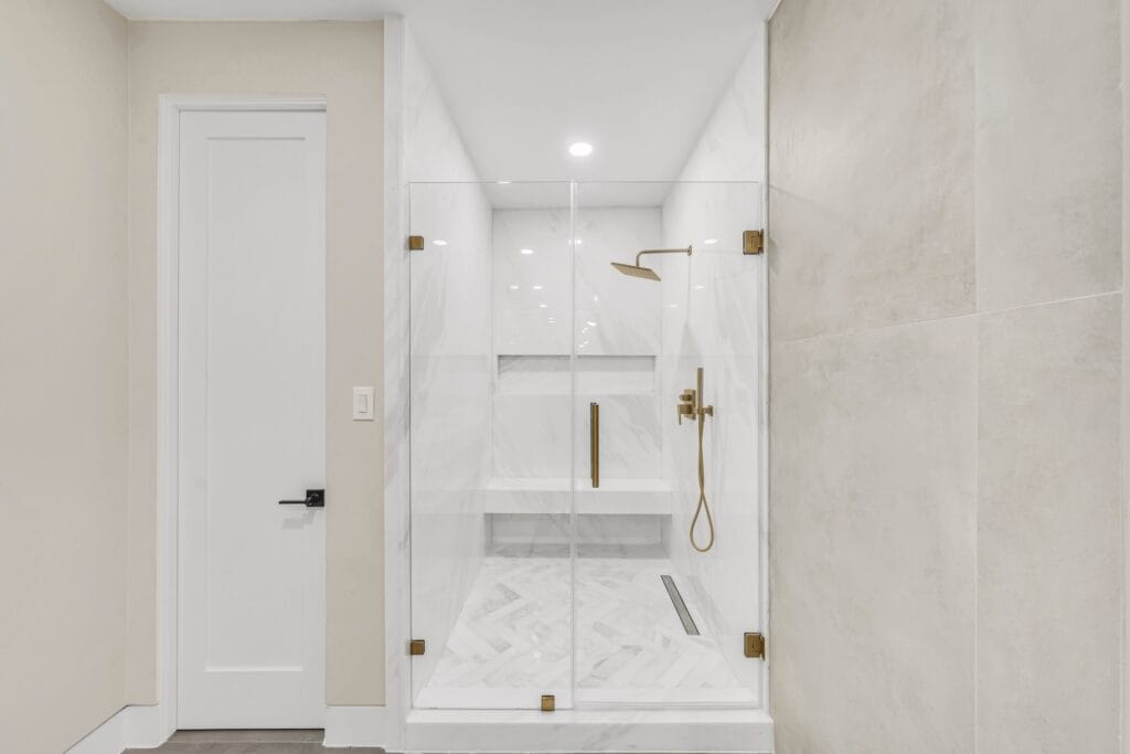 Multi-Bathroom Renovation with Freestanding Tub & Brass-Accented Showers — photo 1