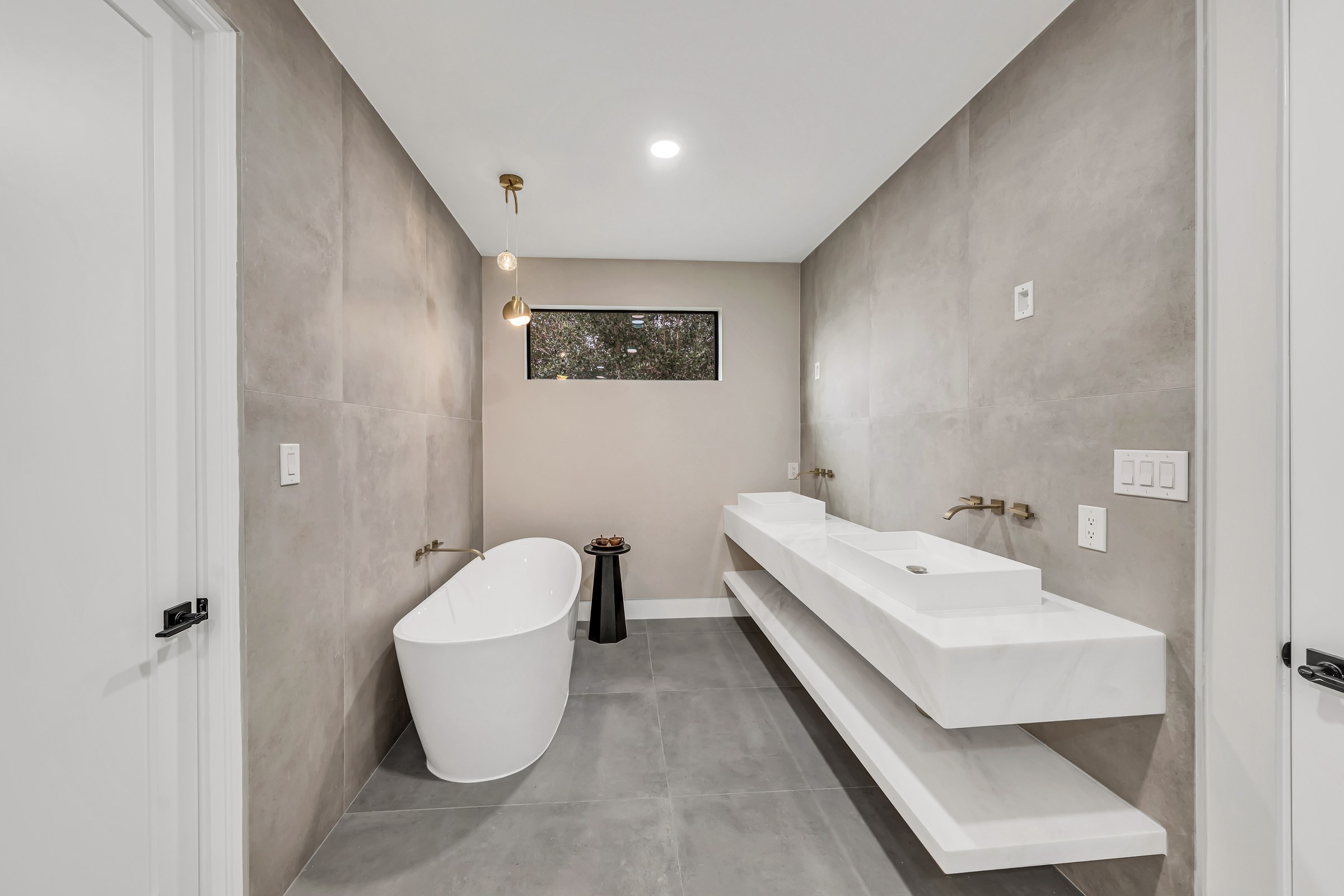Multi-Bathroom Renovation with Freestanding Tub & Brass-Accented Showers