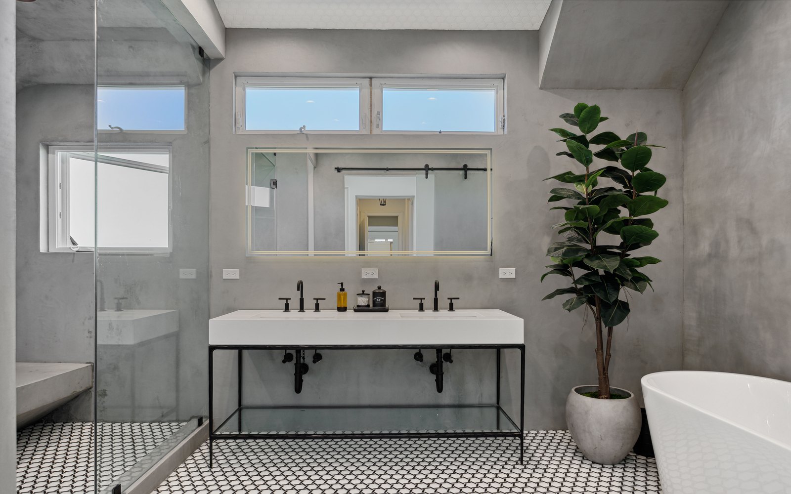 Modern concrete bathroom with matte black fixtures and glass walk-in shower