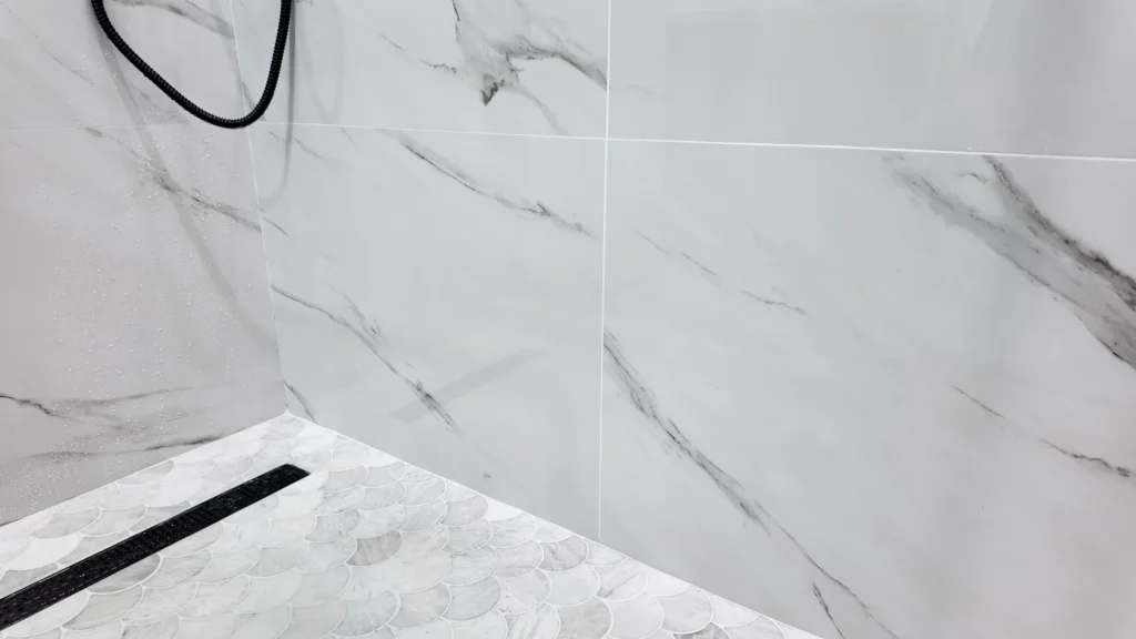 Shower enclosure showing the tiled wall run and a linear drain at the threshold