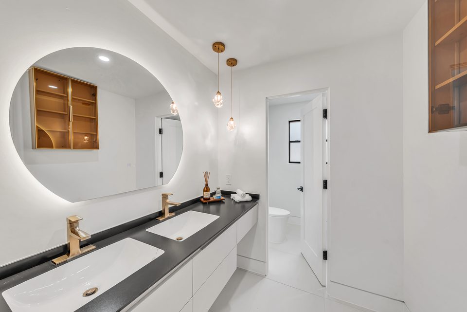 Bathroom vanity with arched mirror and pendant lighting