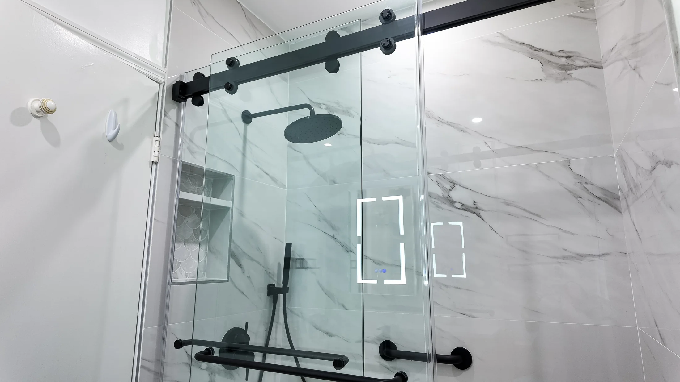 Walk-in shower with sliding glass panels, a rain head and matt black fittings