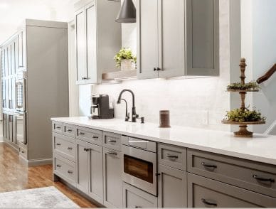 Renovated kitchen with grey shaker cabinetry and quartz counters
