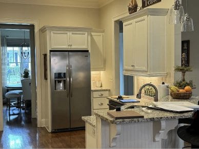 Dated kitchen with cream cabinets and tiled counters, before renovation