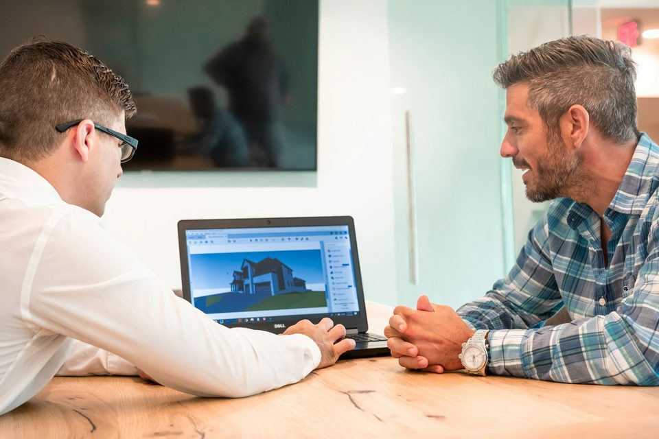 Reviewing a 3D house rendering on screen during planning