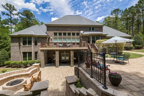 Brick paver patio with stone fire pit, seating wall and raised wood deck